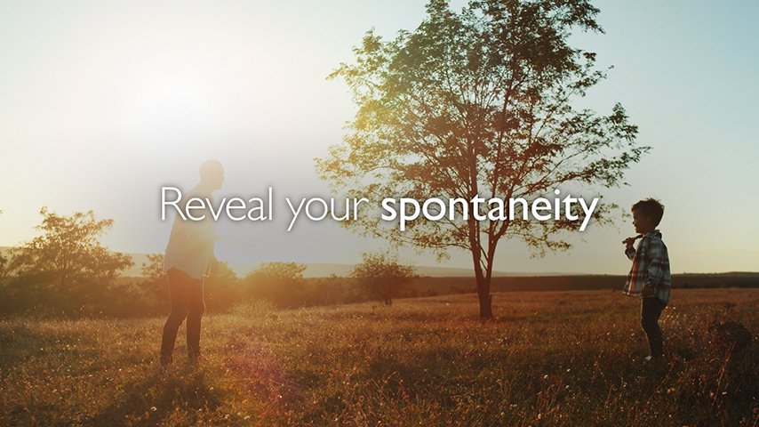 Father and son on a sunny day in front of a tree with text "reveal your spontaneity"