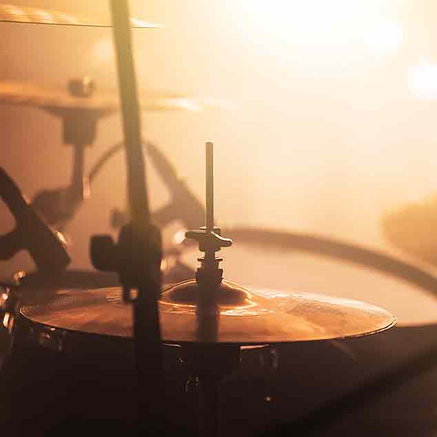 Drums on a concert stage with mist and light.