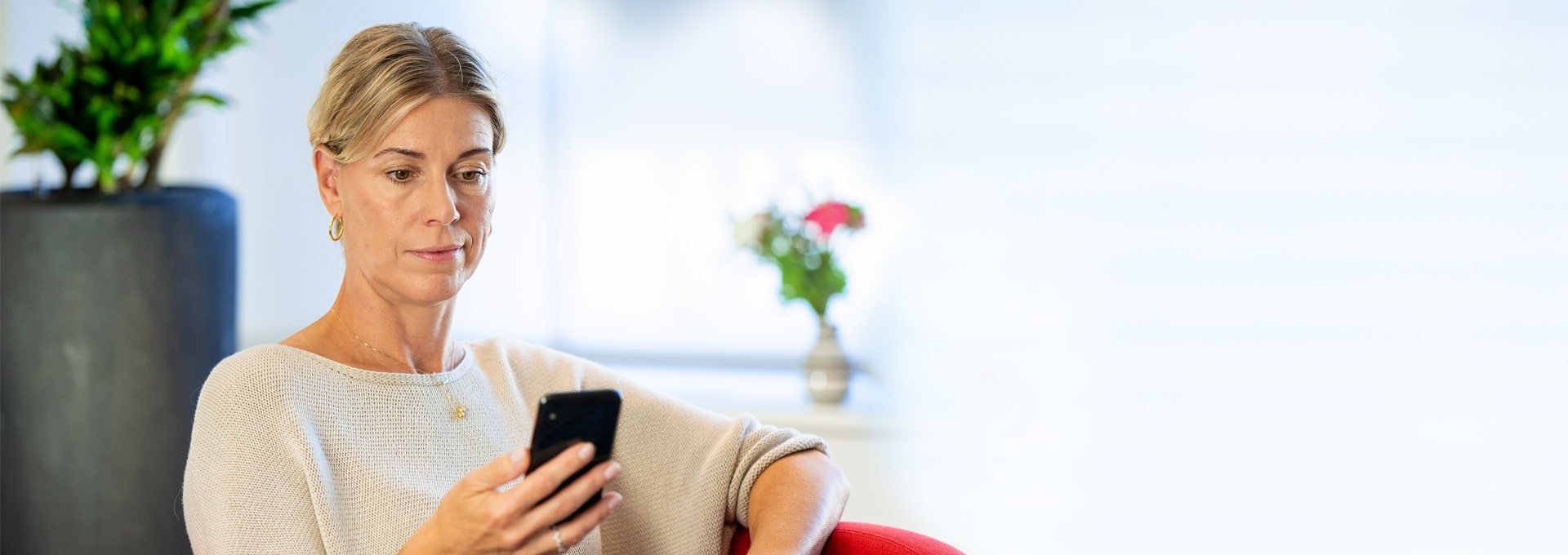 Smiling and relaxed woman looking at her smartphone