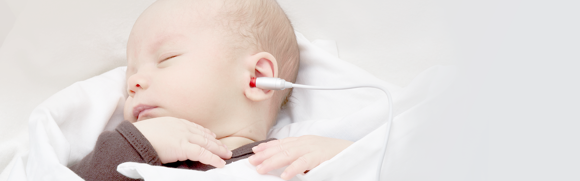 A baby with a probe in its ear