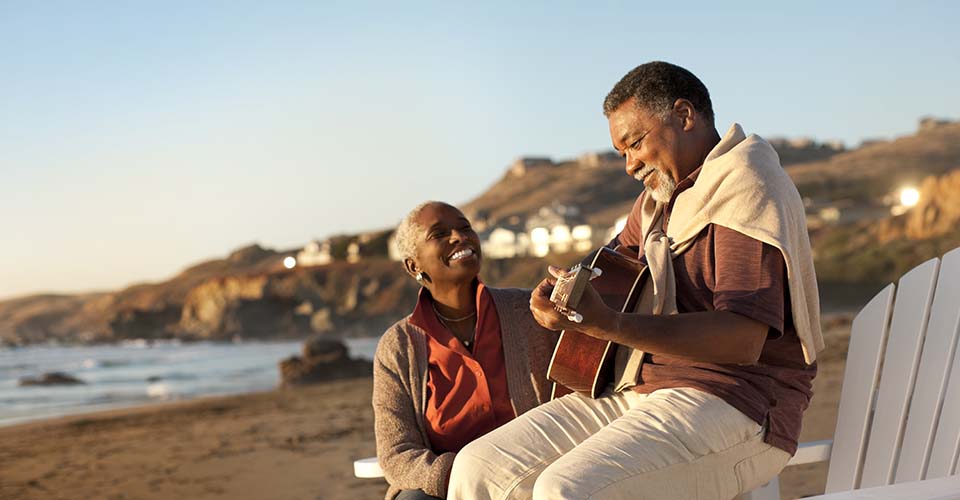 oticon_couple_on_beach_playing_guitar_as_204397825-960x500